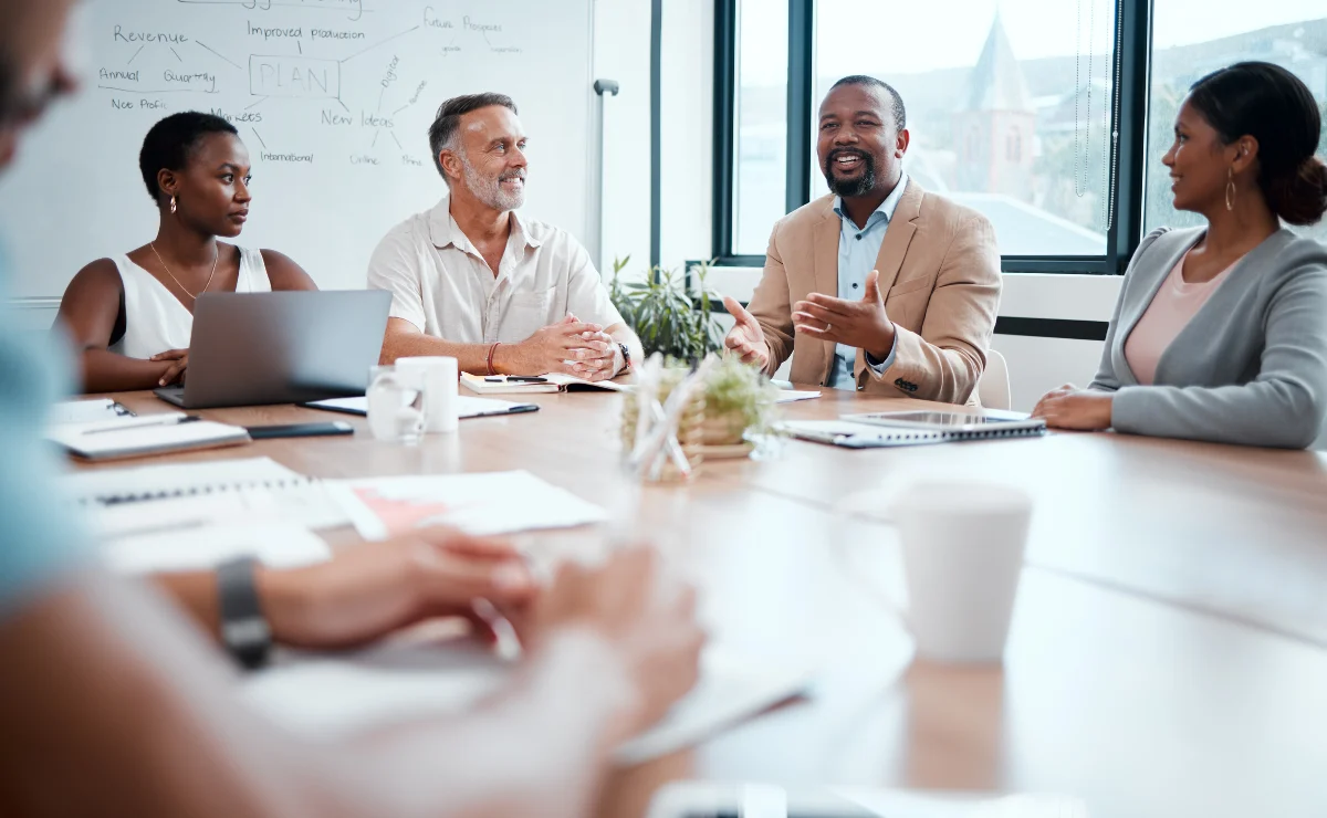 diverse-coworkers-conference-table-meeting-conversation